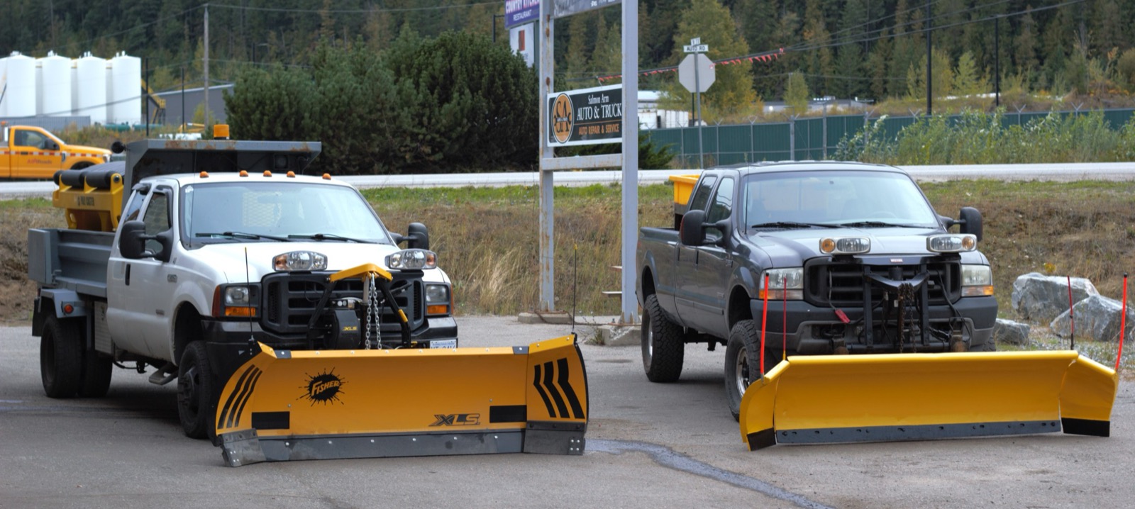 Two Snow Plow Bros plow trucks parked outside Salmon Arm Auto & Truck